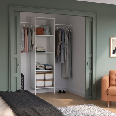Modern closet with AURDAL shelves, organised clothes & storage in green room.