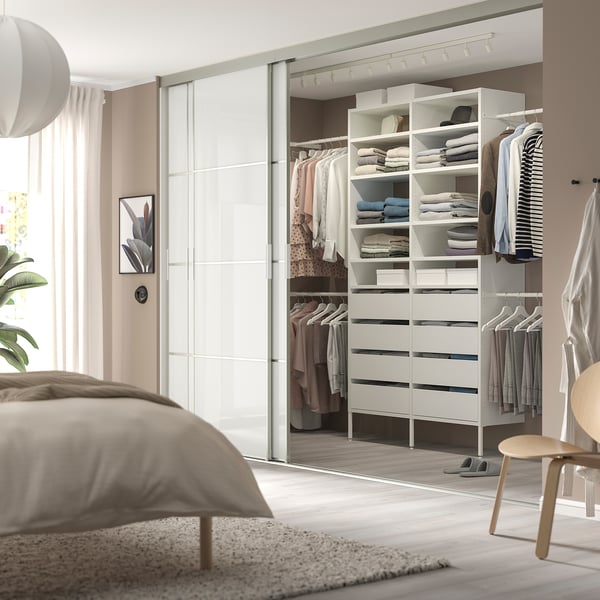 Modern AURDAL white closet with shelves, drawers, and lighting in bedroom.