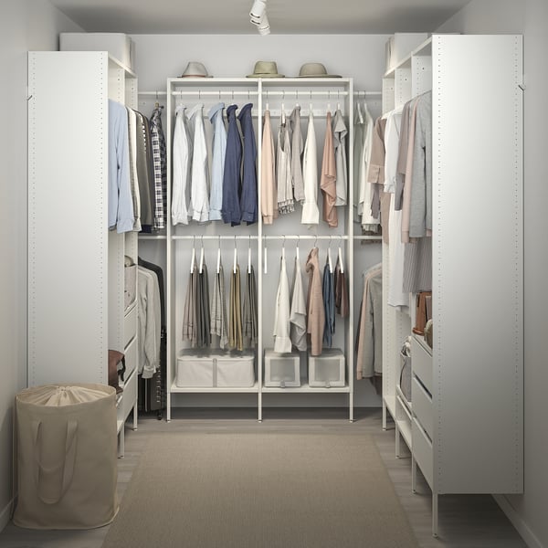 Walk-in closet with adjustable shelves and hanging rods, neatly organised clothes.