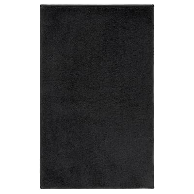 A BACKMÅRA bath mat, black, rectangular, with a soft, textured surface, and a non-slip latex backing.
