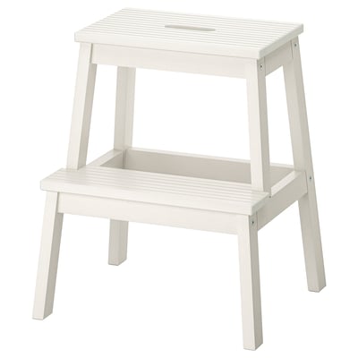 A white BEKVÄM step stool with a rectangular top and four angled legs, made from solid rubberwood.