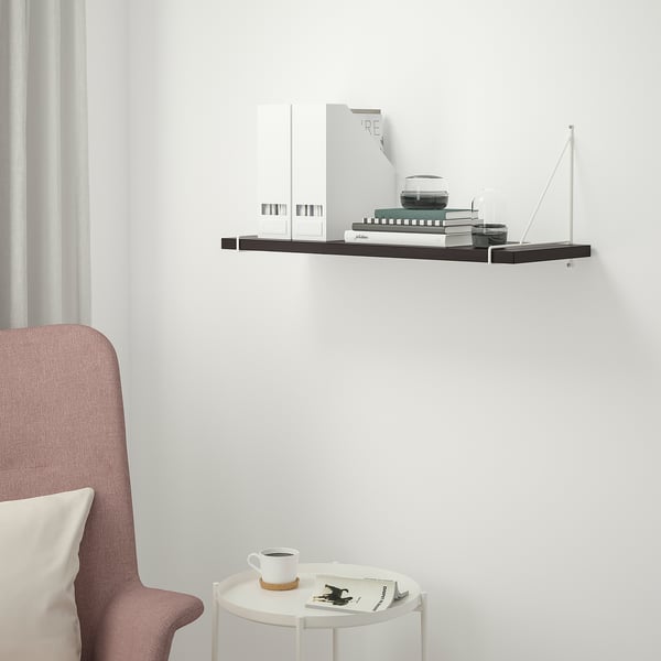 Modern black shelf BERGSHULT on white wall, smaller than chair, holding decor.