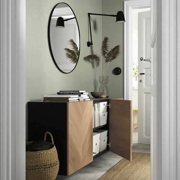 Wall-mounted BESTÅ storage in modern entryway with organised shelves and decor.