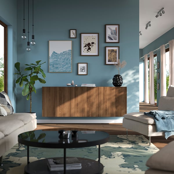 Modern living room with BESTÅ sideboard, art gallery, and glass table between white sofas.