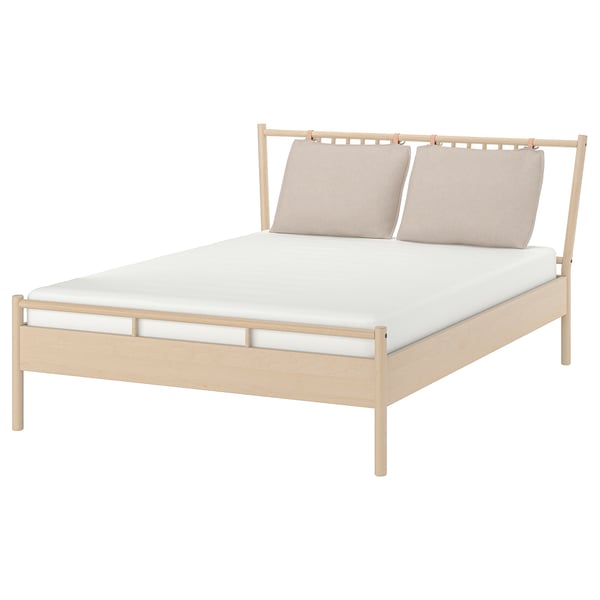 Light wood BJÖRKSNÄS bed with white mattress and headboard, beige pillows.
