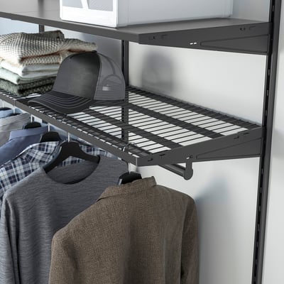 Closet with dark shelves, hanging shirts, jacket, and folded clothes, showing organised storage.