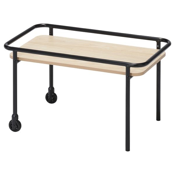 A BRÄNNBOLL side table with black metal frame and wooden top. It has wheels for mobility and a high edge to keep items from sliding off.