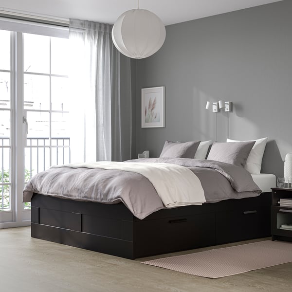Grey bedroom with BRIMNES bed, large windows, simple decor. Bed is dark grey, focal point, larger than nearby balcony.