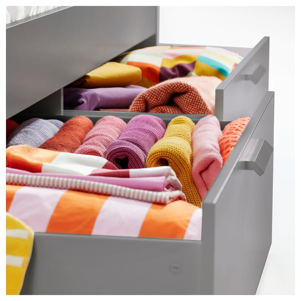 BRIMNES grey storage drawers with folded colourful clothes.