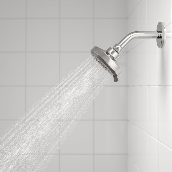 Chrome shower head with full spray function, mounted on wall, releasing water.