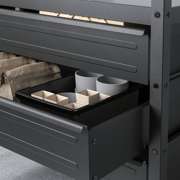 Black metal drawer open showing storage with two mugs and compartments for organising items.