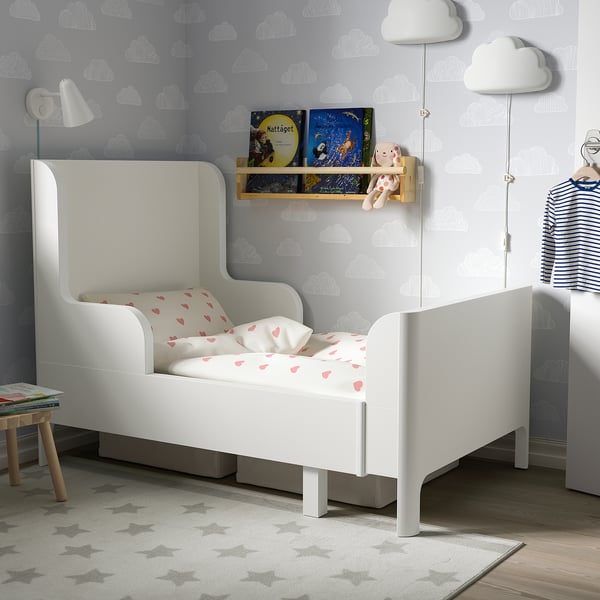Kids room with small white rounded bed, sky walls.