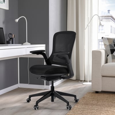 Home office: black CENTERHALV chair at white desk with laptop, sofa, window.