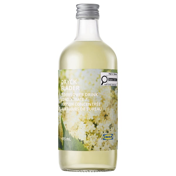 Bottle of ikea dryck flader elderflower drink concentrate. Clear glass, silver cap, white label with green and cream flowers.