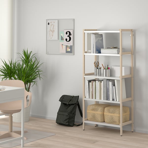 Wooden EKENABBEN shelf with books and supplies, near grey wall and black backpack.