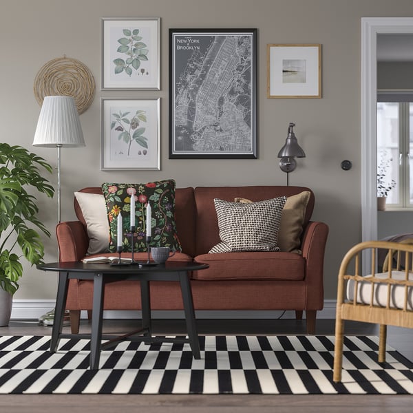 Cosy living room with EKHOLMA sofa, rug, coffee table, plant, and gallery wall.