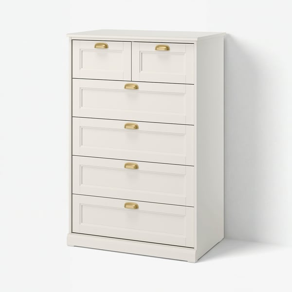 Depicts a white FÅGELFJÄLLET chest of drawers with six drawers, featuring brass-effect handles and a crafted design.