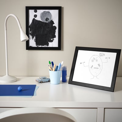 White desk with kids drawing, lamp, pencils, toy car.