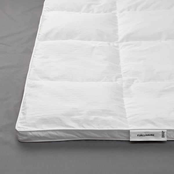 White FJÄLLHAVRE duvet with plush, stitched design displayed on bed.