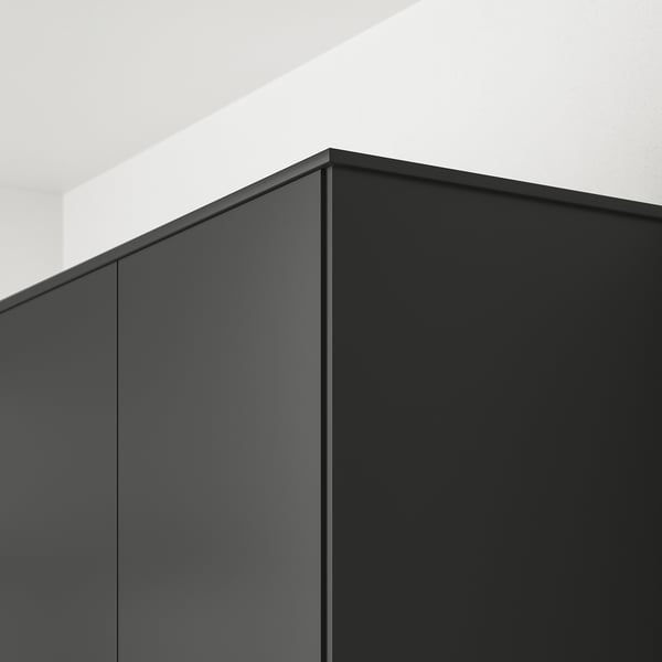 Black kitchen cabinet edge detail with hidden lighting.