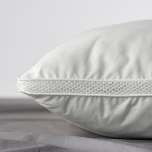 Close-up of a white pillow with smooth fabric and mesh side panels, showcasing its comfort and quality.