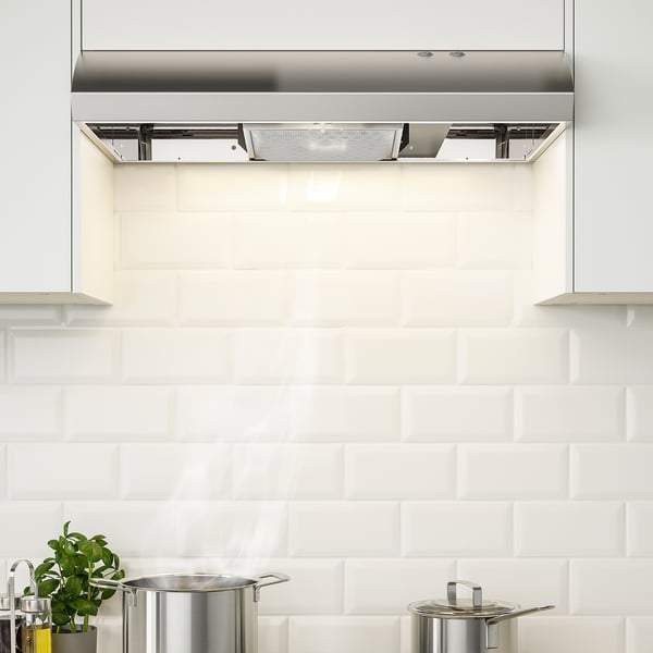 Modern kitchen with built-in stainless hood. Led lighting, visible control panel, and large philtre directly under cabinet.