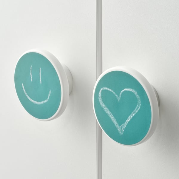 Two white doors with blue circular stickers feature a smiley face and a heart, adding a playful touch to the furniture.