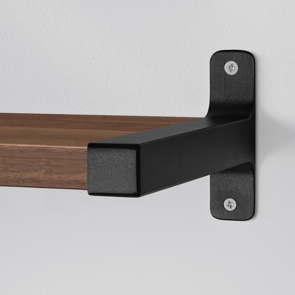 Wall-mounted shelf with black metal brackets securely holding the wooden shelf, showcasing sturdy and modern design.