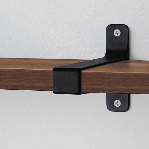 Wooden shelf securely attached to wall with sturdy black metal brackets.
