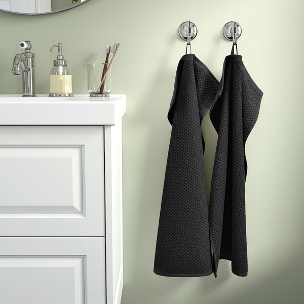 Green bathroom with white cabinet, chrome tap, GULVIAL towels. Or, for brevity: green bathroom with white cabinet and GULVIAL towels.