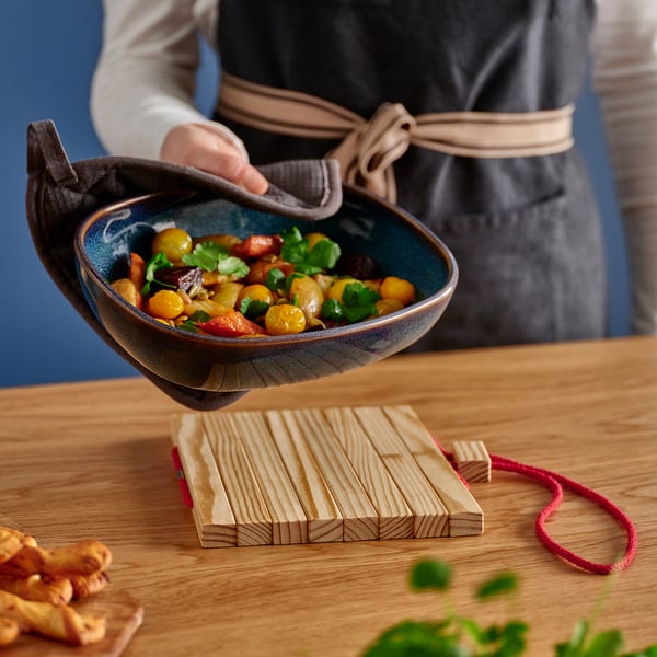 Chef cooking colourful veggies on heat-resistant stand.