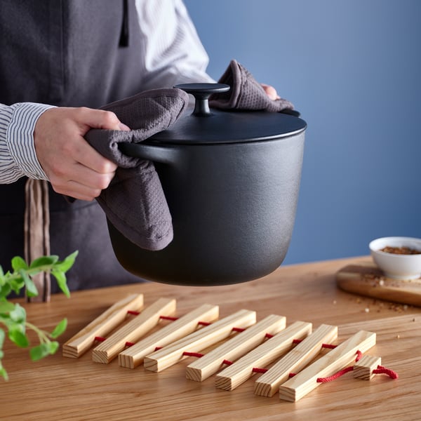Cooking in apron by stove.