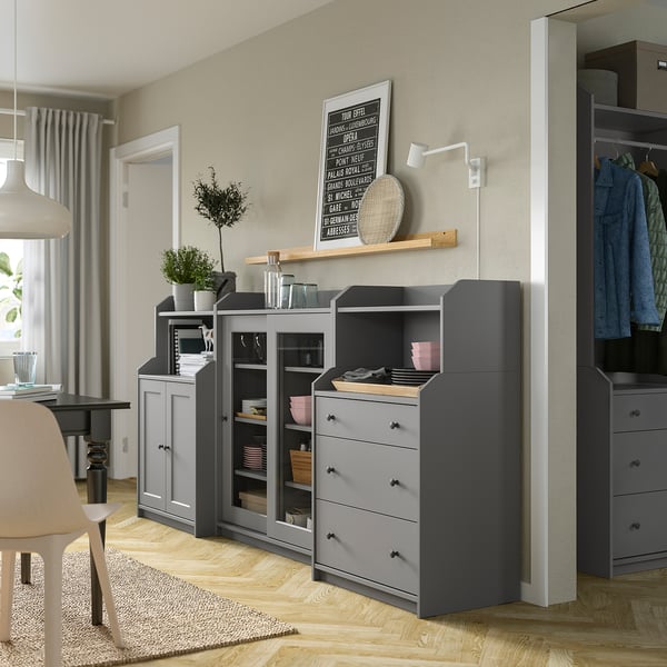 Modern grey wooden cabinet set with shelves, drawers, glass doors, plants, wall art, well-lit room.