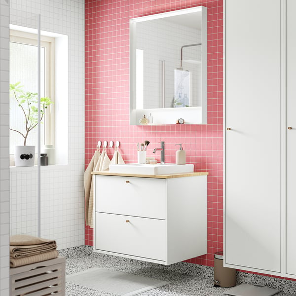 White HAVBÄCK cabinet, wood counter, built-in sink. Mirror, tiles, towels.