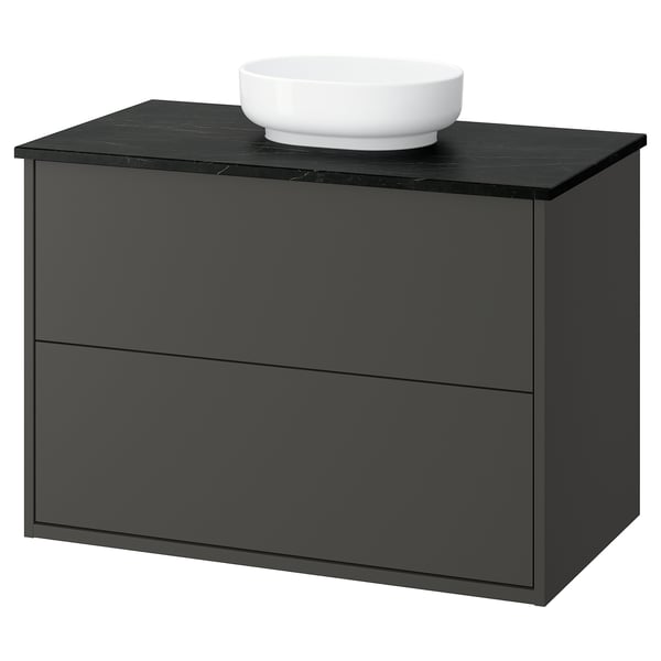 Black bathroom cabinet with round white sink, modern design.