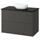 Black bathroom cabinet with round white sink, modern design.