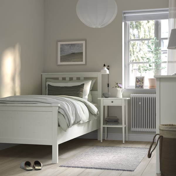 Modern bedroom with HEMNES bed, bedside table, and large window.