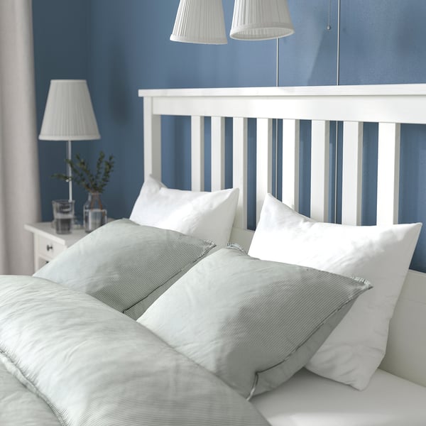 Calm blue bedroom with white bedding on HEMNES bed, featuring slatted headboard and drawers for storage.