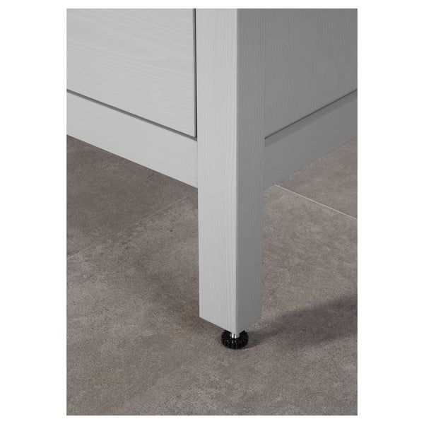 Modern wooden cabinet with sleek, light grey finish. Soft-close, full-extension drawer near grey floor. High-quality design and materials visible.