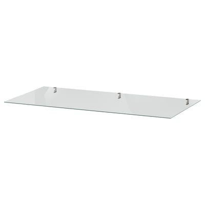 A clear IDANÄS glass shelf, square-shaped, supported by four metal brackets.