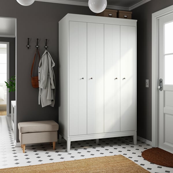 Modern white IDANÄS wardrobe with bifold doors, hooks, and bench in grey entryway.