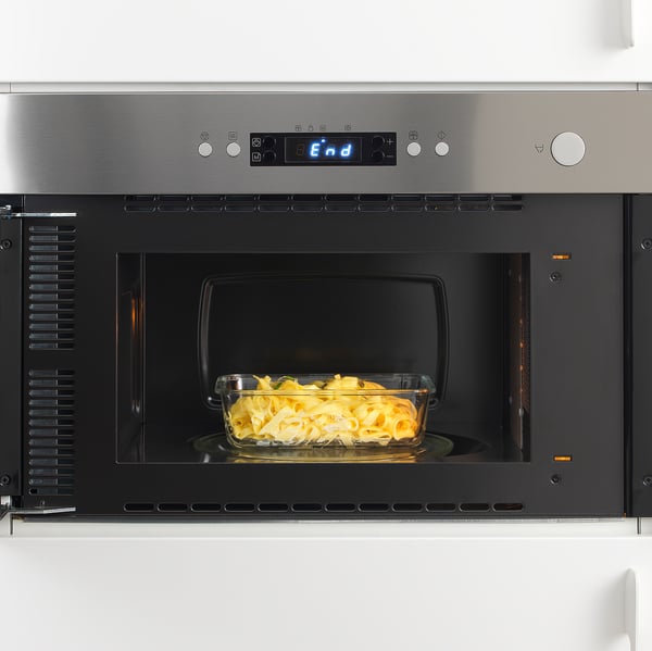 Glass food container inside microwave. Digital display shows end. Once heated, serve from container.