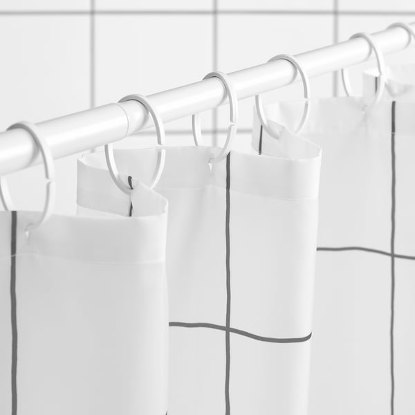 White shower curtain with dark grey tiled design hangs from rings on rod, water-repellent for easy cleaning.