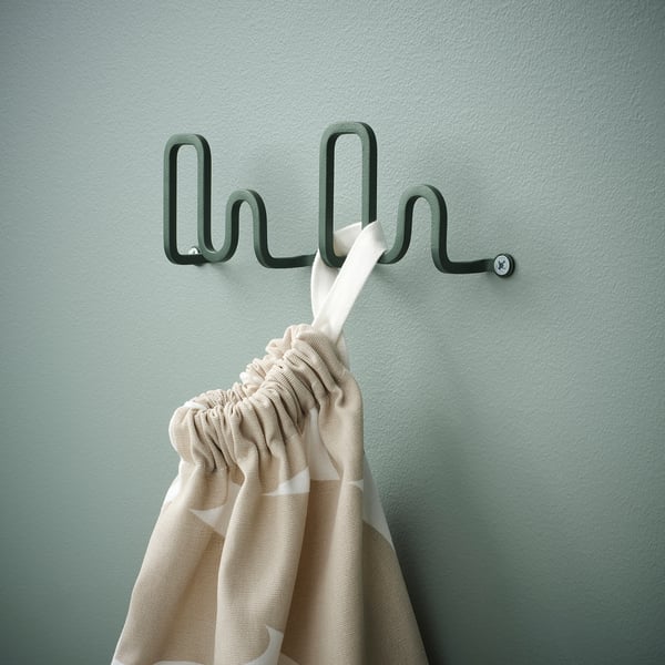 Unique wall hook holding striped towel, modern design, green, wall-mounted.