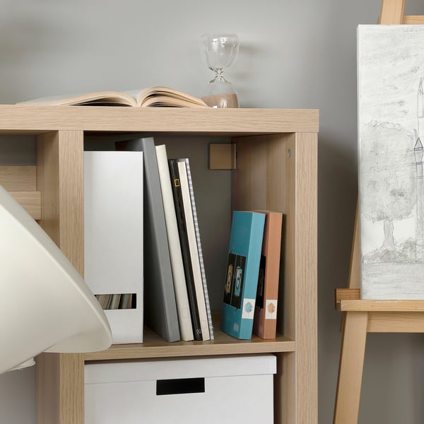 Bookshelf with books, boxes, and a vase, modern and clean.