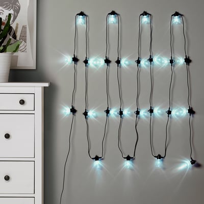 KASTTÅG lighting chain on white wall with warm, inviting lights.
