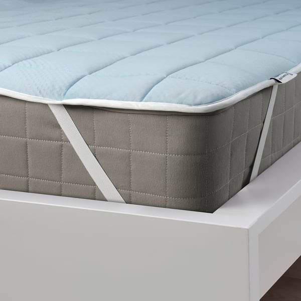 A mattress protector with elastic corners, featuring a cooling blue side and a warming beige side.