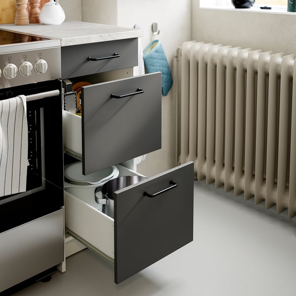 Modern kitchen drawer unit with open drawers showing tools & accessories.
