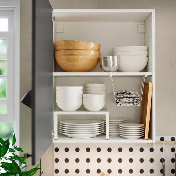 Kitchen cabinet with shelves storing bowls, plates, and utensils, providing organised and accessible kitchenware.