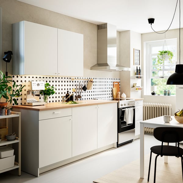 Modern white kitchen with spotted backsplash, essential appliances, and ample storage.
